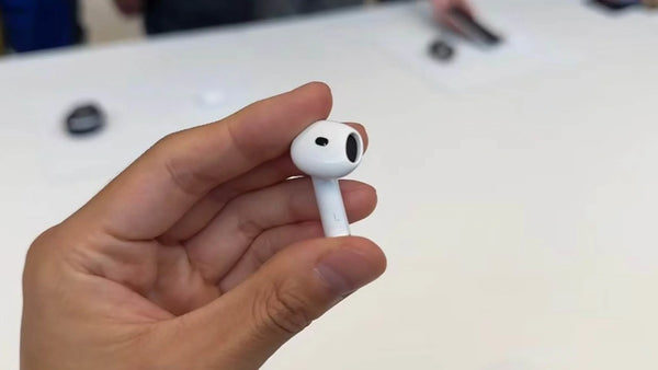 AirPod held in hand for Apple AirPods Live Translation with a compatible iPhone.