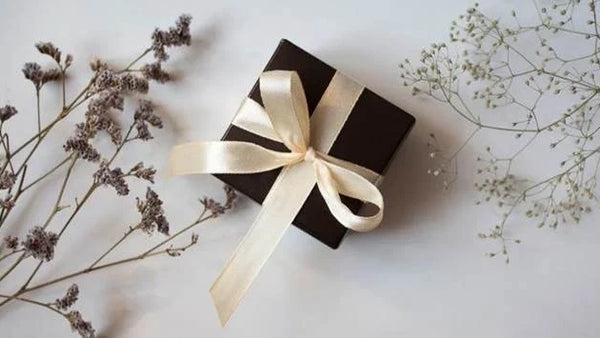 Wrapped gift box with ribbon and dried flowers introducing a guide to the best gifts for men in 2026.
