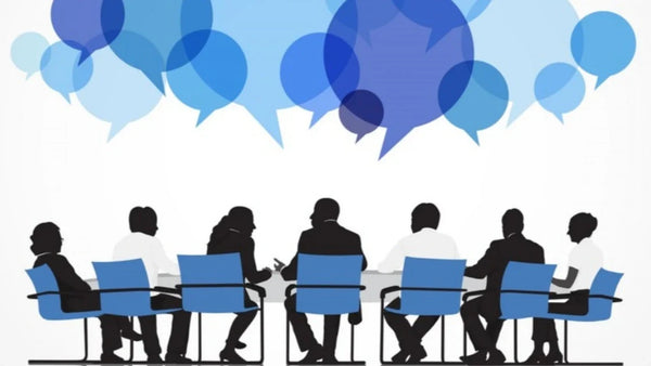 Team discussion with speech bubbles illustrating multi-speaker meeting transcription.