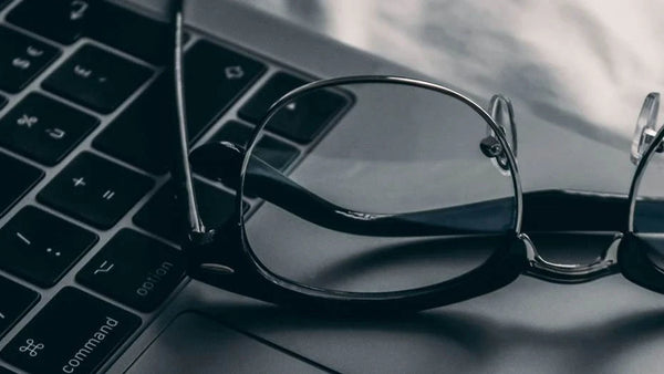 Prescription glasses resting on a laptop keyboard for a guide to progressive, bifocal, and multifocal lenses.