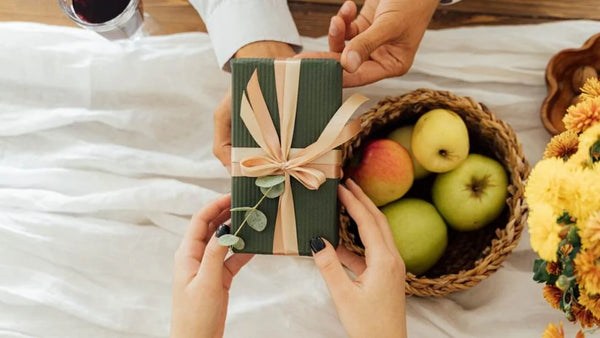 Wrapped Thanksgiving gift beside autumn fruit for a 2026 Thanksgiving gifts guide.