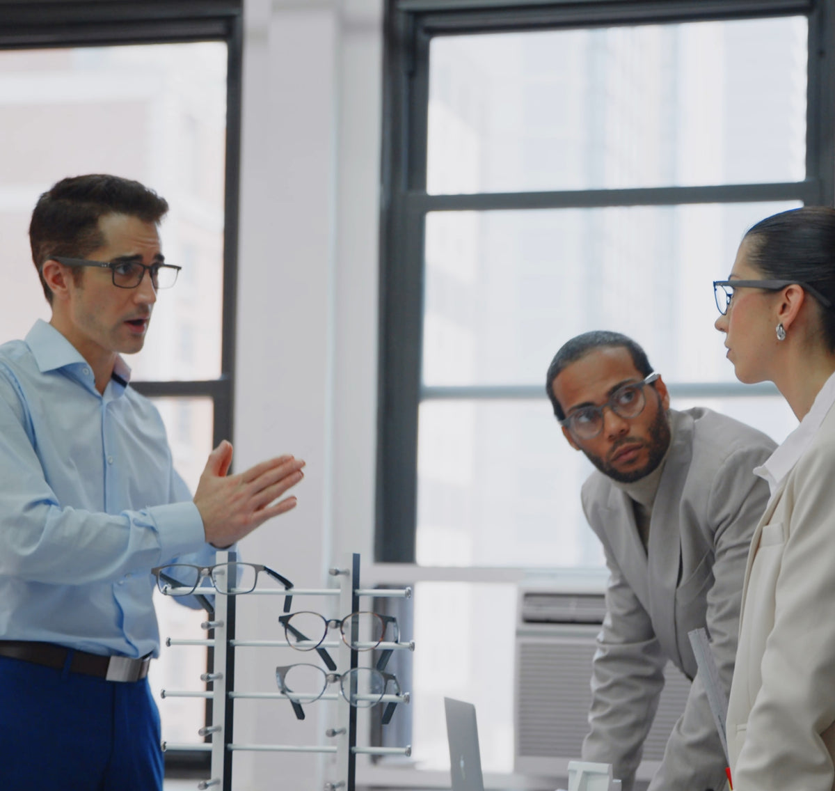 Office team discussing Dymesty AI glasses during a business meeting
