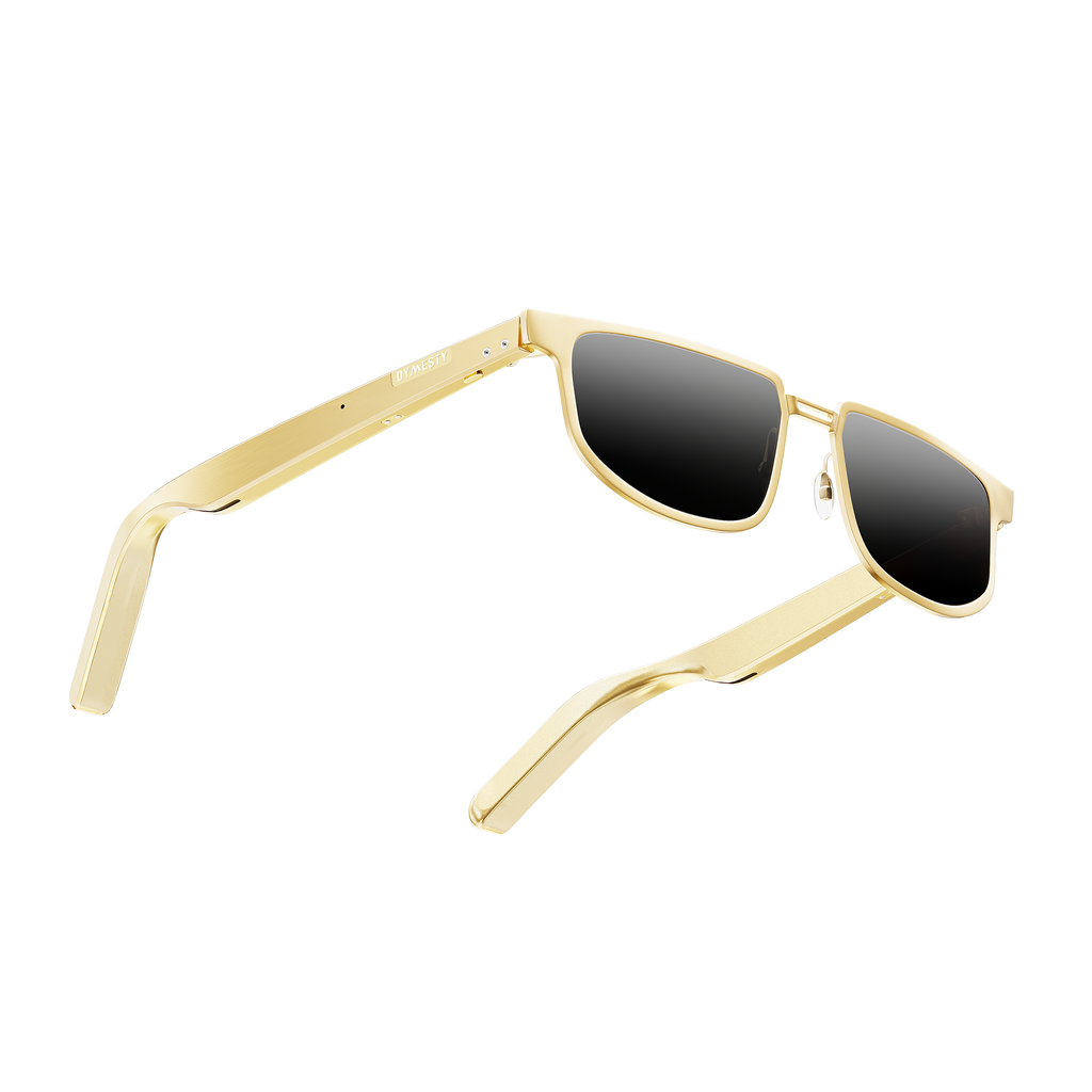 Dymesty Moore Vision AI Smart Sunglasses in champagne gold titanium frame with dark gray lenses, front view on transparent background — 35g lightweight, 48-hour battery, real-time translation in 100 languages, camera-free design