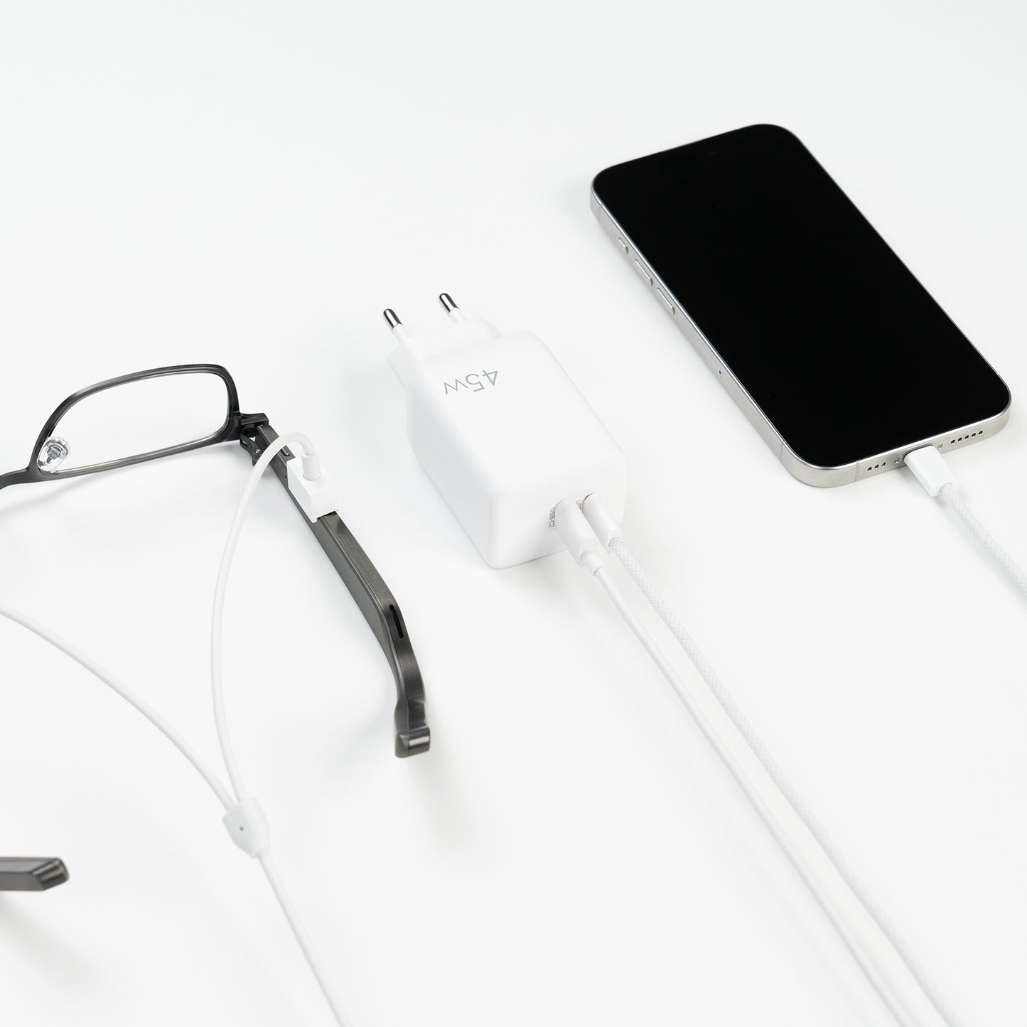Dymesty Power Adapter charging a smartphone and AI glasses simultaneously. The essential tool for multi-device efficiency.